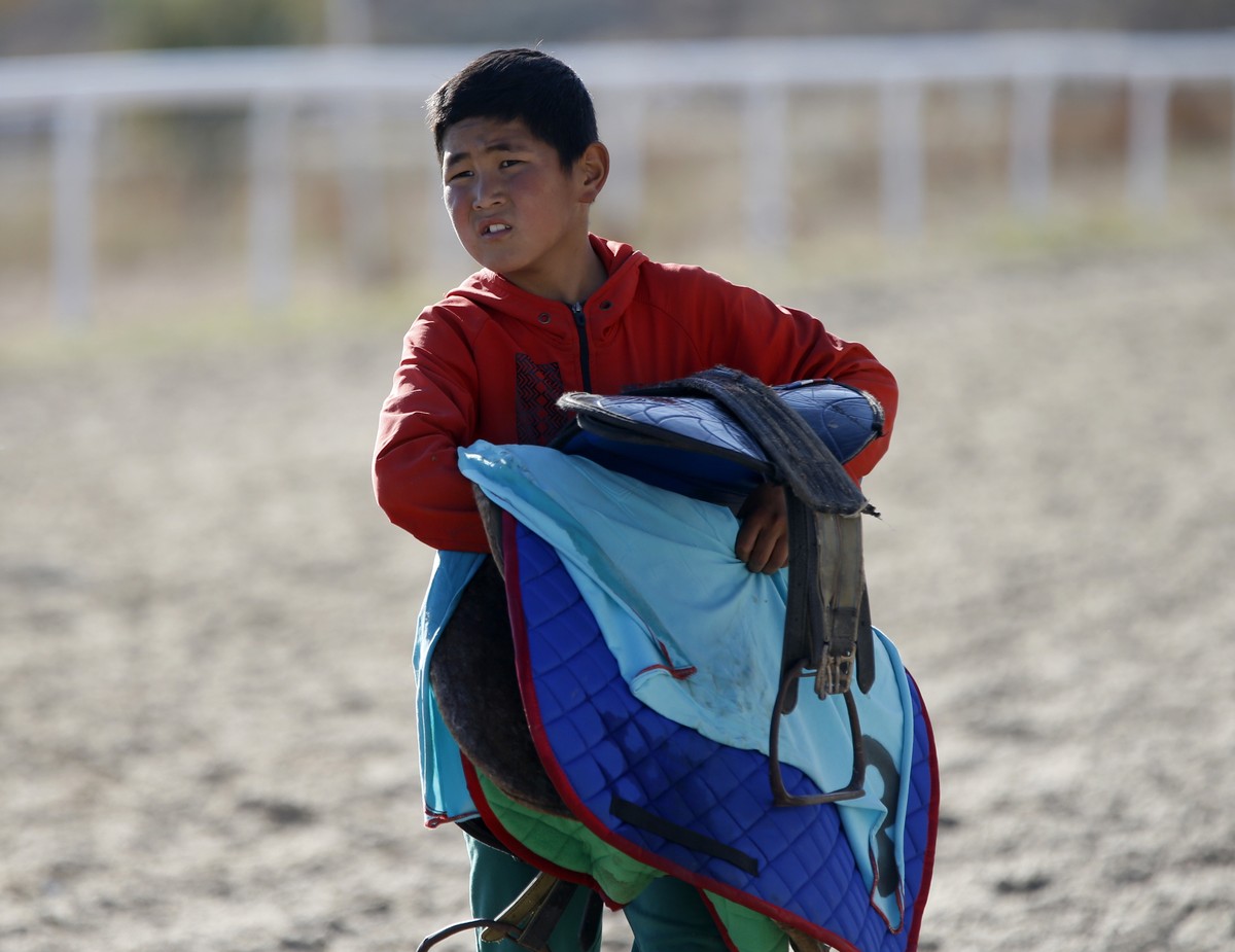 epa10260905 A Kyrgyz boy carries a saddle after one of the races of the 'Jorgo Salysh' (Ambler races) in Cholpon-Ata, some 250 kilometers from Bishkek, Kyrgyzstan, 23 October 2022. The Feder ...