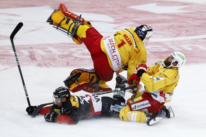 Berns Tristan Scherwey, unten links, prallt vor dem Tor zum 2-0 mit Biels Torhueter Jonas Hiller und Robbie Earl zusammen, im siebten Eishockey Playoff-Halbfinalspiel der National League zwischen dem  ...