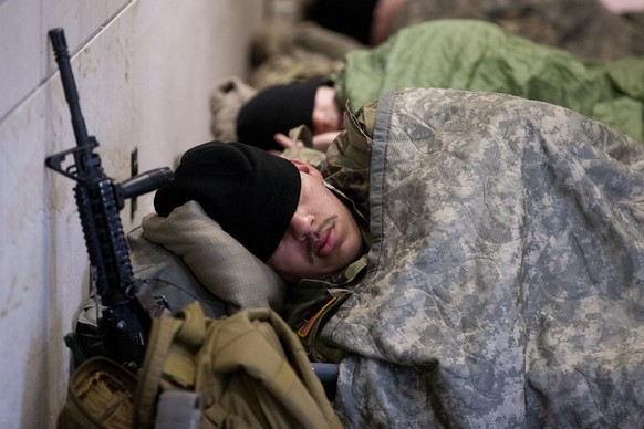 epa08958585 Members of the National Guard rest in the Capitol Visitor Center on Capitol Hill in Washington, DC, USA, 22 January 2021. Hundreds of National Guard troops were allowed to return to the Ca ...