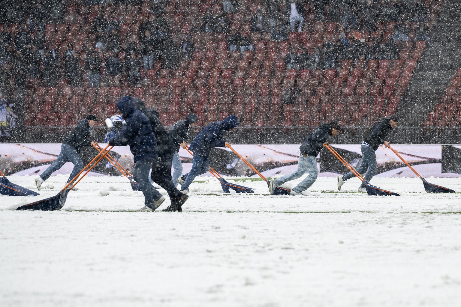 Zuercher Fans helfen bei der Schneeraeumung im Fussball Meisterschaftsspiel der Super League zwischen dem FC Zuerich und dem FC St. Gallen im Letzigrund, am Sonntag, 21. April 2024 in Zuerich. (KEYSTO ...