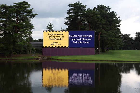 epa09375616 A large screen announces the suspension of play on the 18th hole, due to lightning in the area, during the first round of the Golf events of the Tokyo 2020 Olympic Games at the Kasumigasek ...