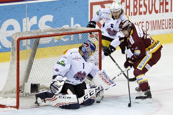 Biel&#039;s goalkeeper Jonas Hiller, left, saves a puck past Biel&#039;s defender Nicholas Steiner, center, and Geneve-Servette&#039;s center Jim Slater, of U.S.A., right, during the game of National  ...