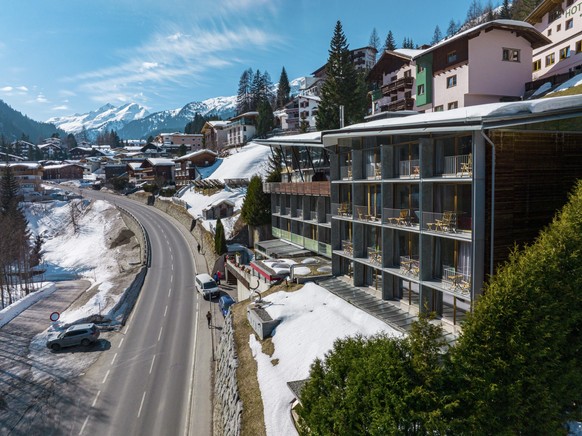 St. Anton am Arlberg. March 10, 2022. Hotel lux alpinae on sunny day in town. High angle view of luxurious ski resort against snowcapped mountains. Empty road leading towards village during winter. xk ...