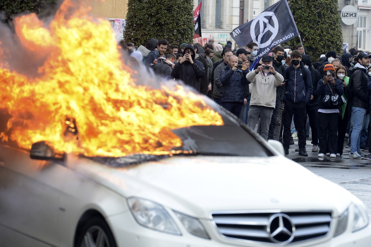Protesters watch a burning car during a demonstration Thursday, April 13, 2023 in Rennes, western France. Protesters opposed to President Emmanuel Macron's unpopular plan to raise the retirement  ...