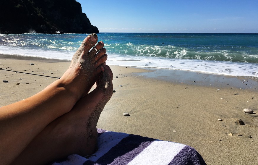 epa08734601 A tourist enjoys the sun on the beach at Ermones in Corfu, Greece, 09 October 2020 (issued 10 October 2020). Lockdowns and travel restrictions across Europe caused by the Coronavirus have  ...