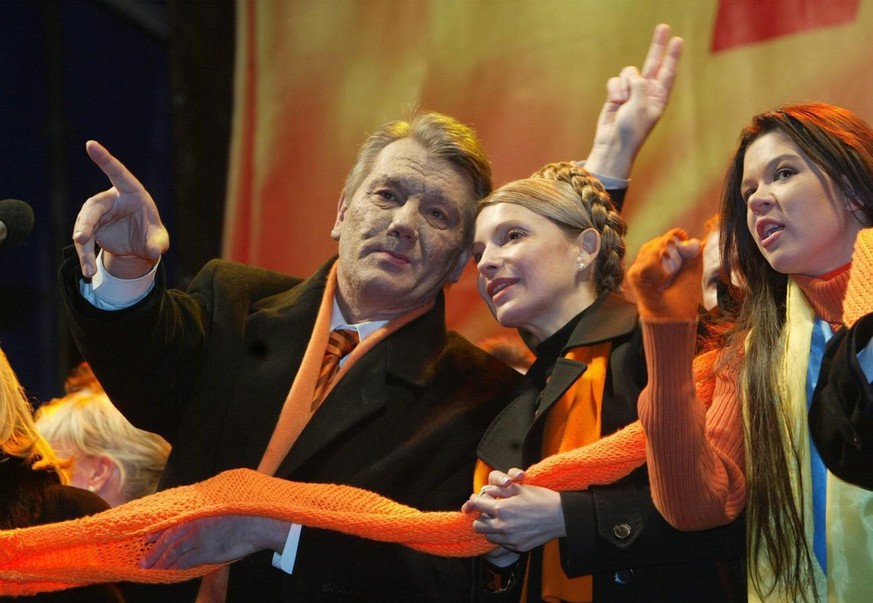 Opposition presidential candidate Viktor Yushchenko (L) gesticulates as his top political ally Yulia Timoshenko (C) and winner of Eurovision 2004 Ruslana Lyzhychko (R) listen during a rally in Indepen ...
