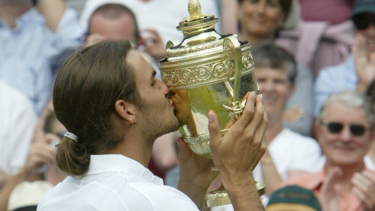 Switzerland's Roger Federer kisses the Men's Singles trophy after defeating Australia's Mark Philippoussis in the final of the All England Lawn Tennis Championships on the Centre Court  ...