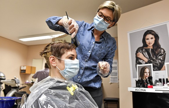 Hairdresser Ute Augustin colors hair of a customer at a barber shop in Gelsenkirchen, Germany, Monday, March 1, 2021. Hairdressers across Germany have reopened for business this morning after a more t ...