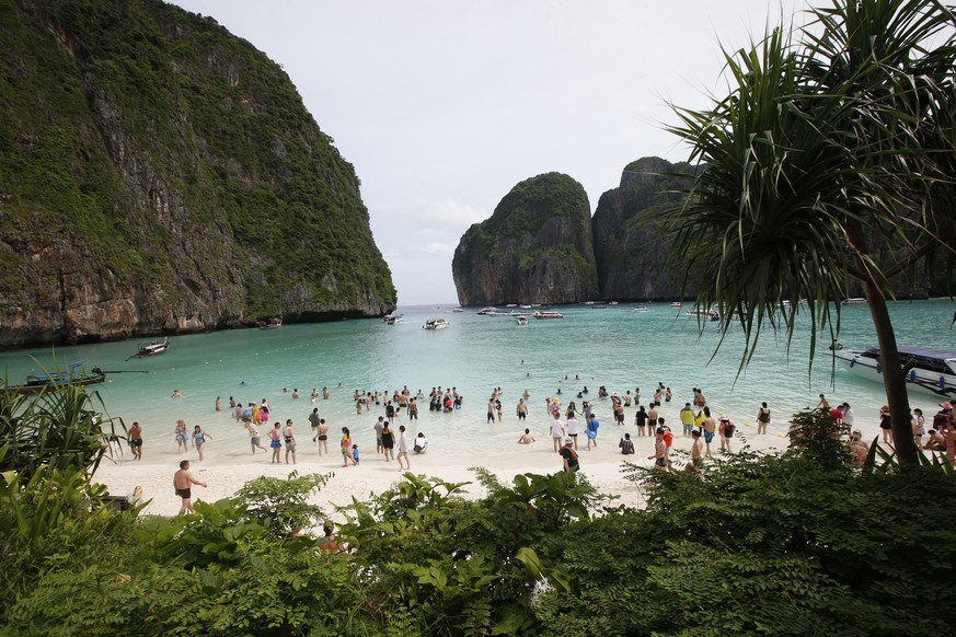 FILE - In this May 31, 2018, file photo, tourists walk the beach of Maya Bay, Phi Phi Leh island in Krabi province, Thailand. The American Society of Travel Agents is starting to refer to agents as 't ...