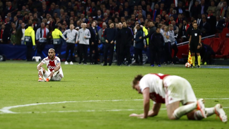 Ajax&#039;s Hakim Ziyech and Ajax&#039;s Frenkie de Jong, right, react after Tottenham scored their third goal during the Champions League semifinal second leg soccer match between Ajax and Tottenham  ...