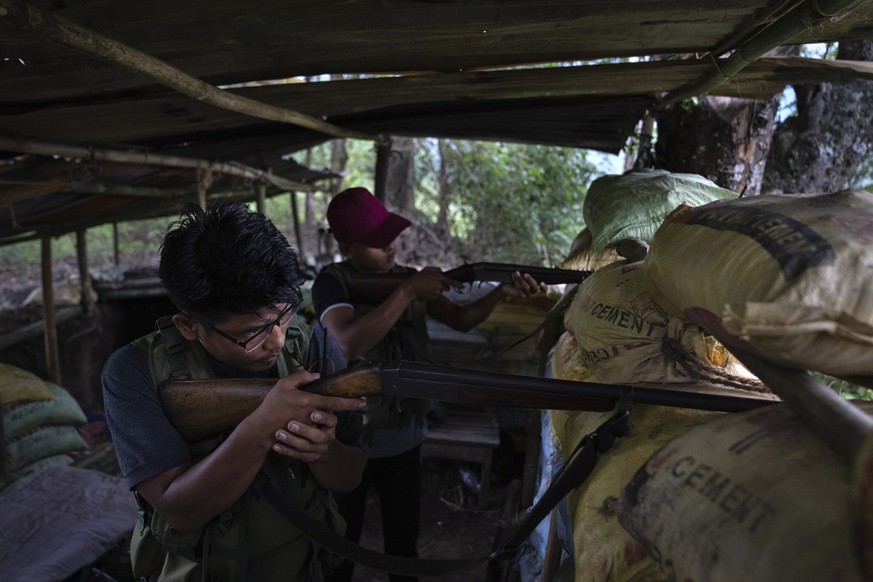 Zuan Vaiphei, 32, left, an armed tribal Kuki, keeps a watch on rival Meitei community bunkers, along a de facto frontline which dissect the area into two ethnic zones in Churachandpur, in the northeas ...