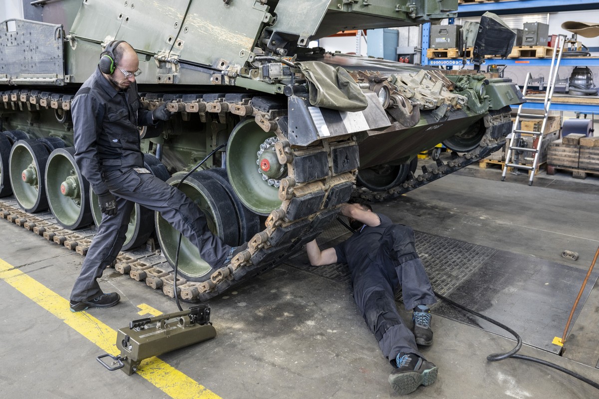 Mechaniker warten die Raupen an einem Panzer vom Typ Leopard 2 in einer Wartungshalle der RUAG, am Montag, 20. Maerz 2023, in Thun. (KEYSTONE/Peter Schneider)