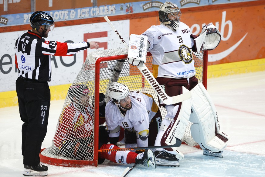 Berns Joel Vermin, links, und Servettes Josh Jooris liegen im Tor von Servettes Torhueter Robert Mayer, neben Schiedsrichter Stefan Huerlimann, im Eishockey Meisterschaftsspiel der National League zwi ...