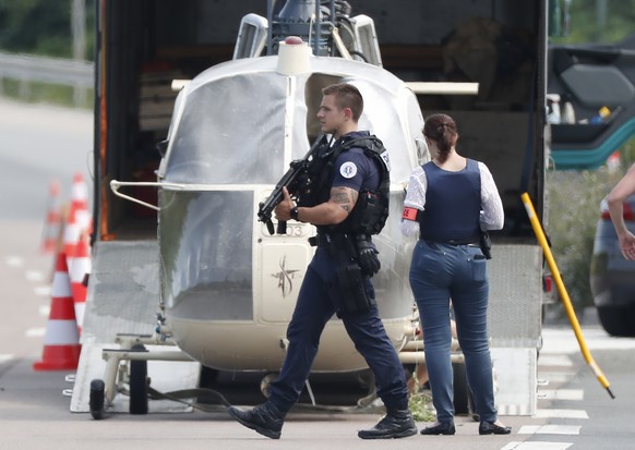 epa06855503 Armed police stand by as investigators transport an Alouette II helicopter allegedly abandoned by French prisoner Redoine Faid and suspected accomplices after his escape from prison in…