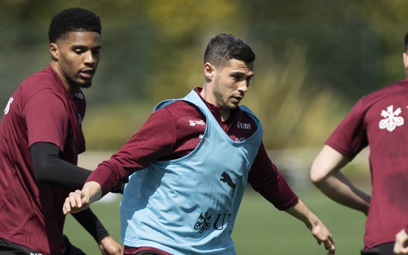 Die Spieler der Schweizer Fussballnationalmannschaft, Simon Sohm, 2. links, und Remo Freuler, Mitte, kaempfem um den ball waehrend einem Training, am Dienstag, 18. Maerz 2025, in The Campus, in Almanc ...