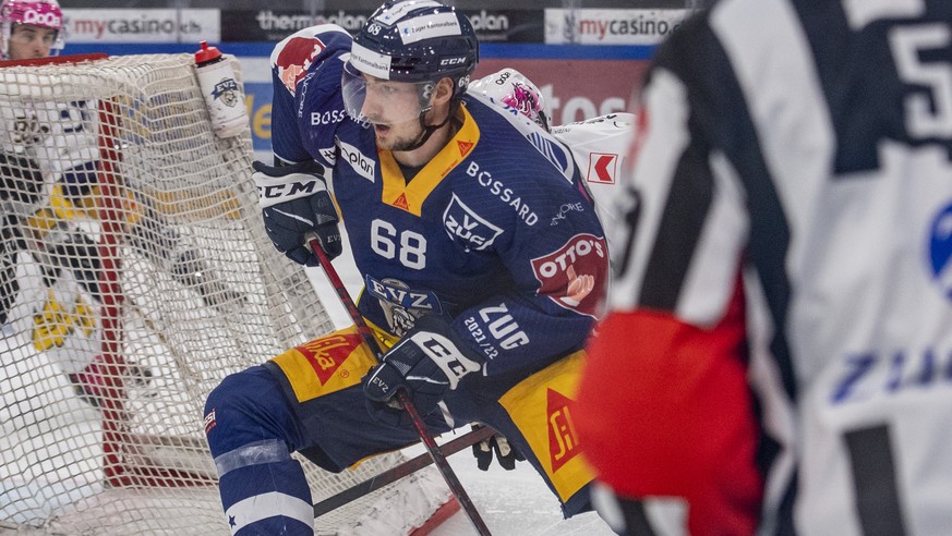 Fabrice Herzog, mitte, von Zug im Spiel gegen Torhueter Tim Wolf, links, von Ajoie beim Eishockey Qualifikationsspiel der National League zwischen dem EV Zug und dem HC Ajoie am Freitag, 24. September ...