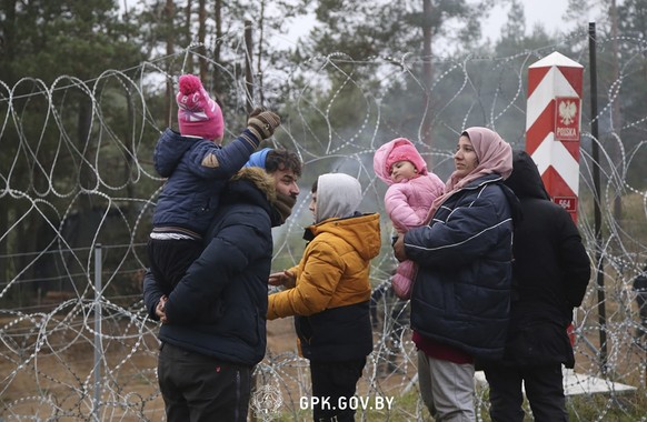 In this handout photo released by State Border Committee of the Republic of Belarus on Wednesday, Nov. 10, 2021, Migrants from the Middle East and elsewhere stand near near the barbed wire gathering a ...