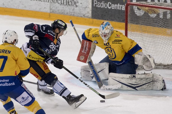 Reto Suri, links, von Zug im Spiel gegen Torhueter Gilles Senn, rechts, von Davos beim fuenften Eishockey Playoff Halbfinalspiel der National League A zwischen dem EV Zug und dem HC Davos am Donnersta ...