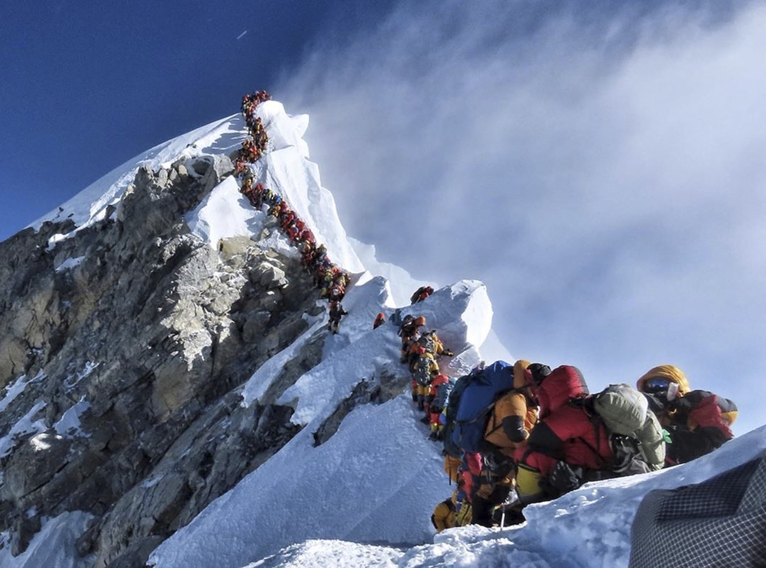 In this photo made on May 22, 2019, a long queue of mountain climbers line a path on Mount Everest. About half a dozen climbers died on Everest last week most while descending from the congested summi ...