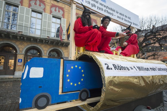 Als Urner Teufel verkleidete Aktionisten auf einer goldenen Gotthardröhre mit der Aufschrift «2. Röhre = 1 Million mehr Lastwagen».