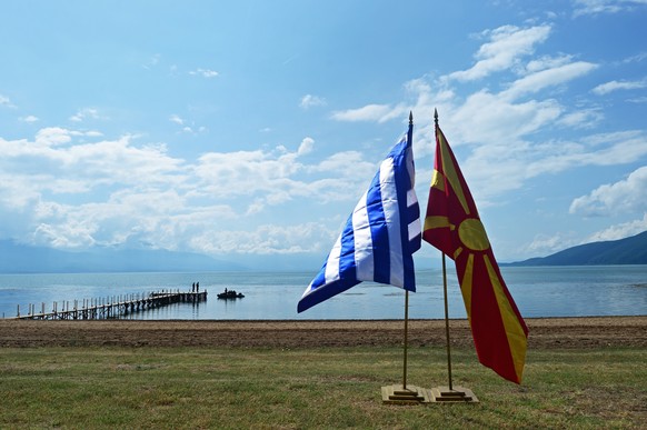 epa06814777 The flags of Greece (L) and the Former Yugoslav Republic of Macedonian (R) stand at the shores of Lake Prespes near Otesevo, the Former Yugoslav Republic of Macedonia (FYROM), 17 Junie 201 ...