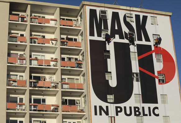 FILE - In this May 16, 2020, file photo, a billboard is installed on an apartment building encouraging people to wear face masks in Cape Town, South Africa, on the 51st day of a strict government lock ...