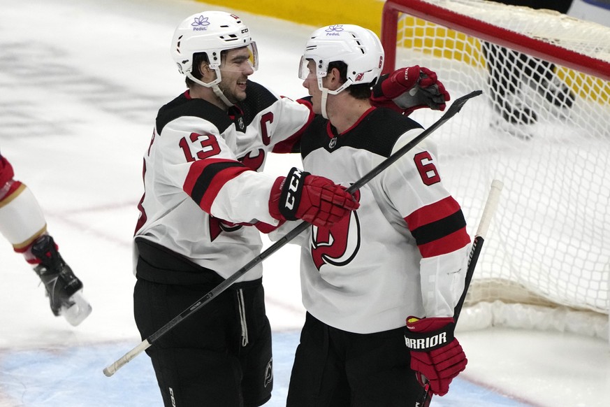 New Jersey Devils defenseman John Marino (6) is congratulated by center Nico Hischier (13) after scoring a goal during the third period of an NHL hockey game against the Florida Panthers, Saturday, Ja ...