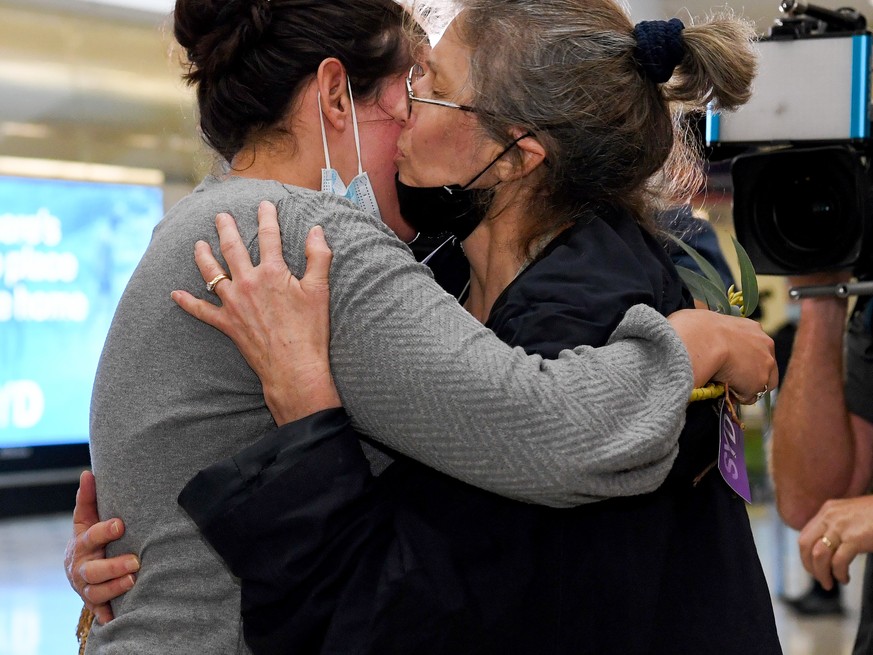 epa09556620 A traveller (R) arriving on one of the first international flights is greeted by her daughter at Sydney International Airport, in Sydney, Australia, 01 November 2021. The first passengers  ...