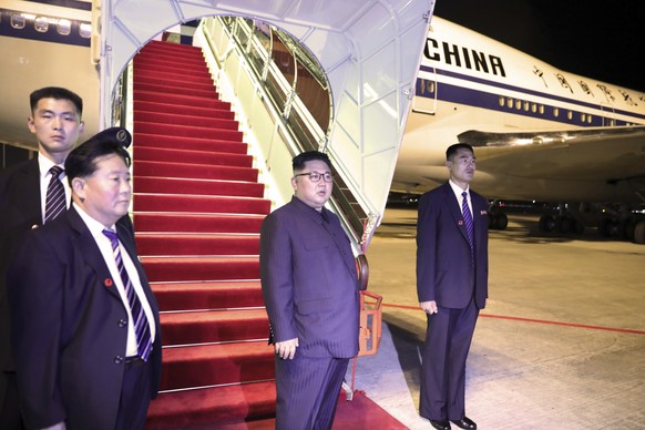 In this photo released by the Ministry of Communications and Information, Singapore, North Korean leader Kim Jong Un, center, stands before boarding the airplane, at Changi airport, following the summ ...