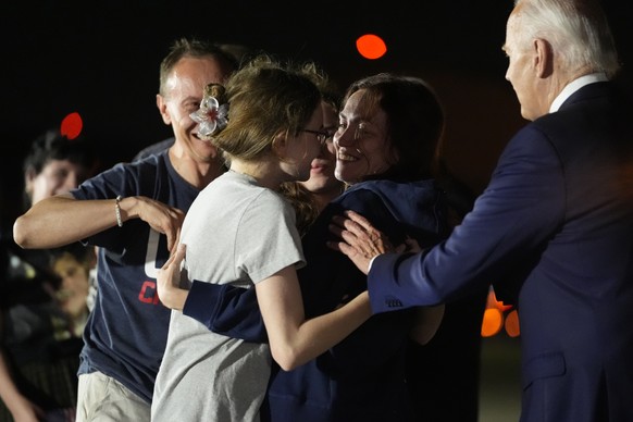 President Joe Biden, from right, approaches Alsu Kurmasheva, who is hugging her daughters Bibi Butorin, Miriam Butorin and husband Pavel Butorin, at Andrews Air Force Base, Md., following her release  ...