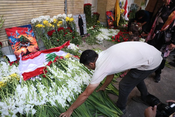epa11612222 An Iranian man places flowers in front of the Lebanese embassy in Tehran, Iran, 18 September 2024. Lebanon&#039;s Ministry of Health said at least 12 people have been killed and more than  ...