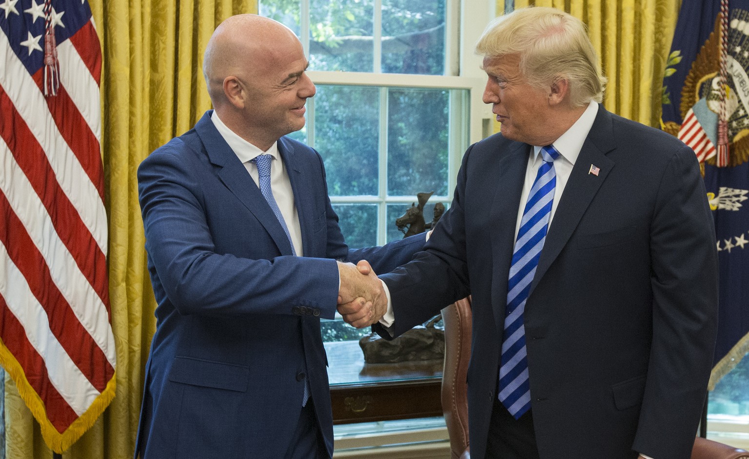 epa06979413 US President Donald J. Trump (R) shakes hands with President of FIFA Gianni Infantino (L) during their meeting in the Oval Office of the White House in Washington, DC, USA, 28 August 2018. ...