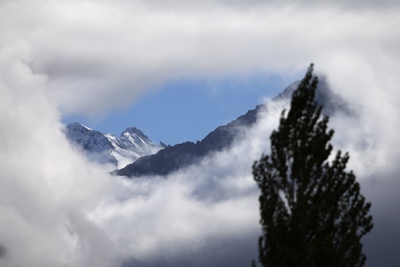 Ein Loch in der Nebeldecke gibt die Sicht auf die Berge frei, am Donnerstag, 8. Oktober 2015, in Meiringen im Berner Oberland. (KEYSTONE/Peter Klaunzer)