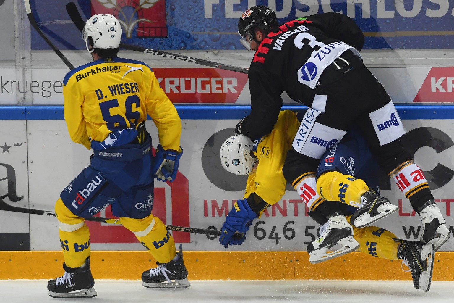 Davos&#039; player Dino Wieser, Davos&#039; player Sven Jung, Lugano&#039;s player Julien Vauclair, from left, during the preliminary round game of National League Swiss Championship 2018/19 between H ...