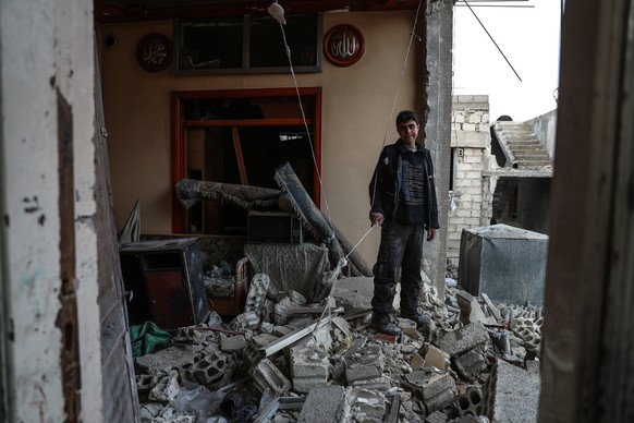 epa06421826 A boy stands among the rubble of his destroyed house in the aftermath of airstrikes on Mesraba, Eastern al-Ghouta, bombed several times in recent days, Syria, 06 January 2018. According to ...