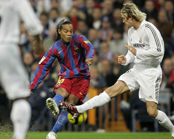 FC Barcelona's Brazilian player Ronaldinho, left, fights for the ball with Real Madrid's English player David Beckham during a Spanish league soccer match at the Bernabeu stadium in Madrid,  ...