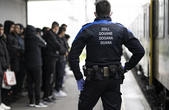 Fluechtlinge aus einem Zug aus Oesterreich werden von Grenzwaechtern zur Kontrolle gebracht, am Mittwoch, 16. November 2022, in Buchs. Seit dem Sommer 2021 gelangen vermehrt afghanische Fluechtlinge a ...