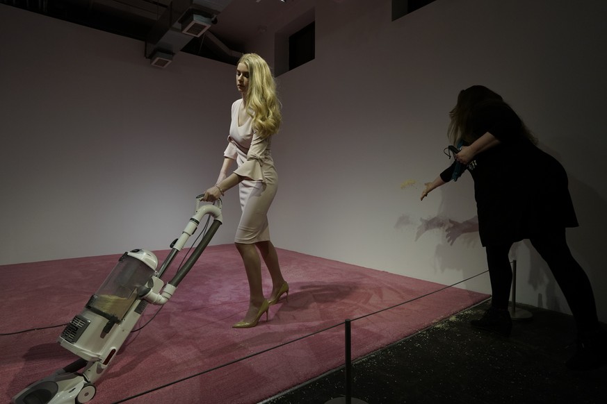 A spectator tosses crumbs for an Ivanka Trump lookalike to vacuum at Jennifer Rubell&#039;s art exhibit &quot;Ivanka Vacuuming 2019&quot; on Tuesday, Feb. 5, 2019, at Flashpoint Gallery in Washington. ...