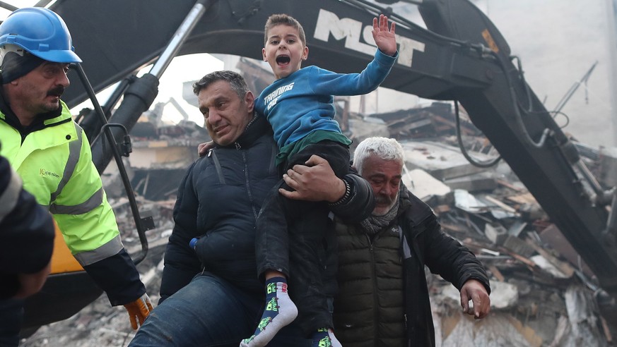 epaselect epa10453979 Eight-year-old Yigit Cakmak (C) reacts after being rescued from the site of a collapsed building, some 52 hours after a major earthquake, in Hatay, Turkey, 08 February 2023. More ...