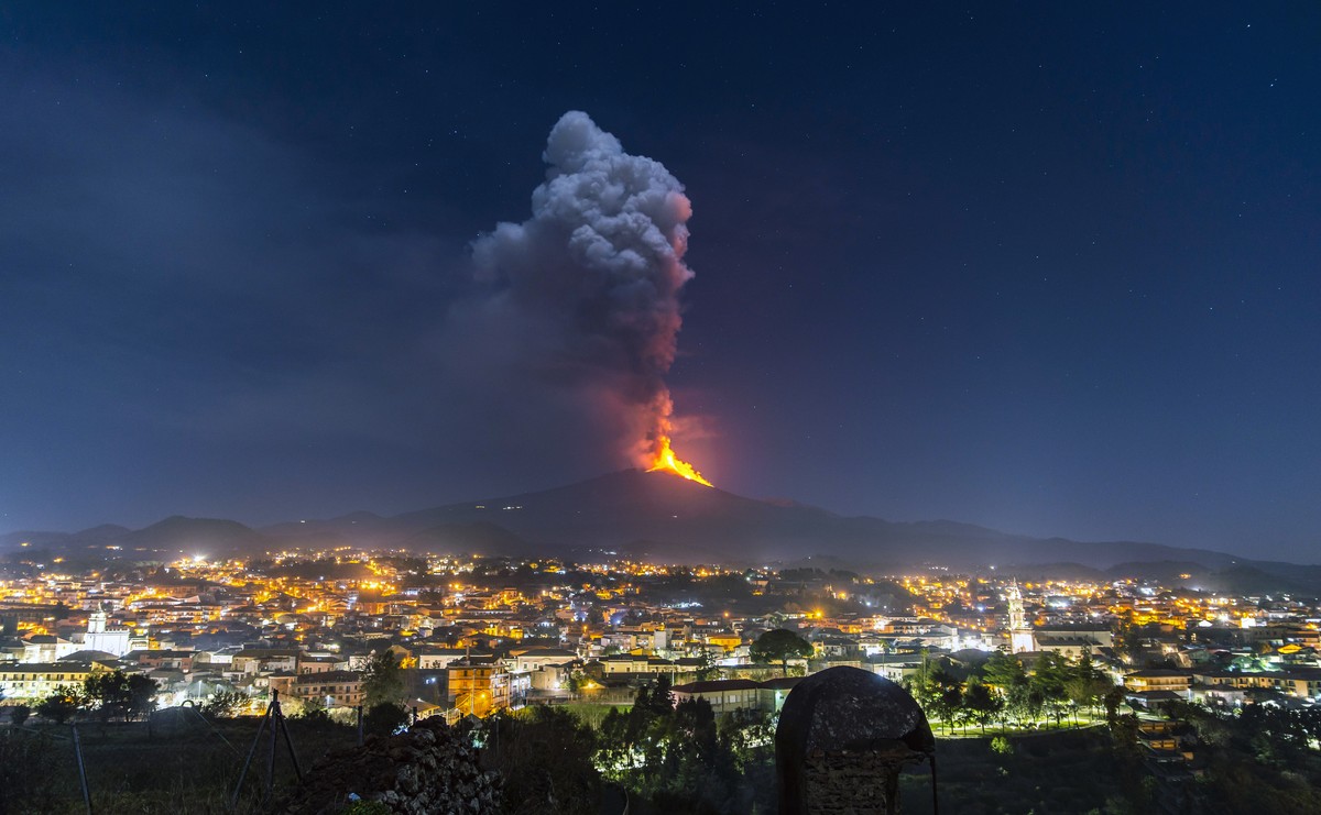 Flames and smoke billowing from a crater, as seen from the southern side of the Mt Etna volcano, tower over the city of Pedara, Sicily, Wednesday night, Feb. 24, 2021. Europe's most active volcan ...