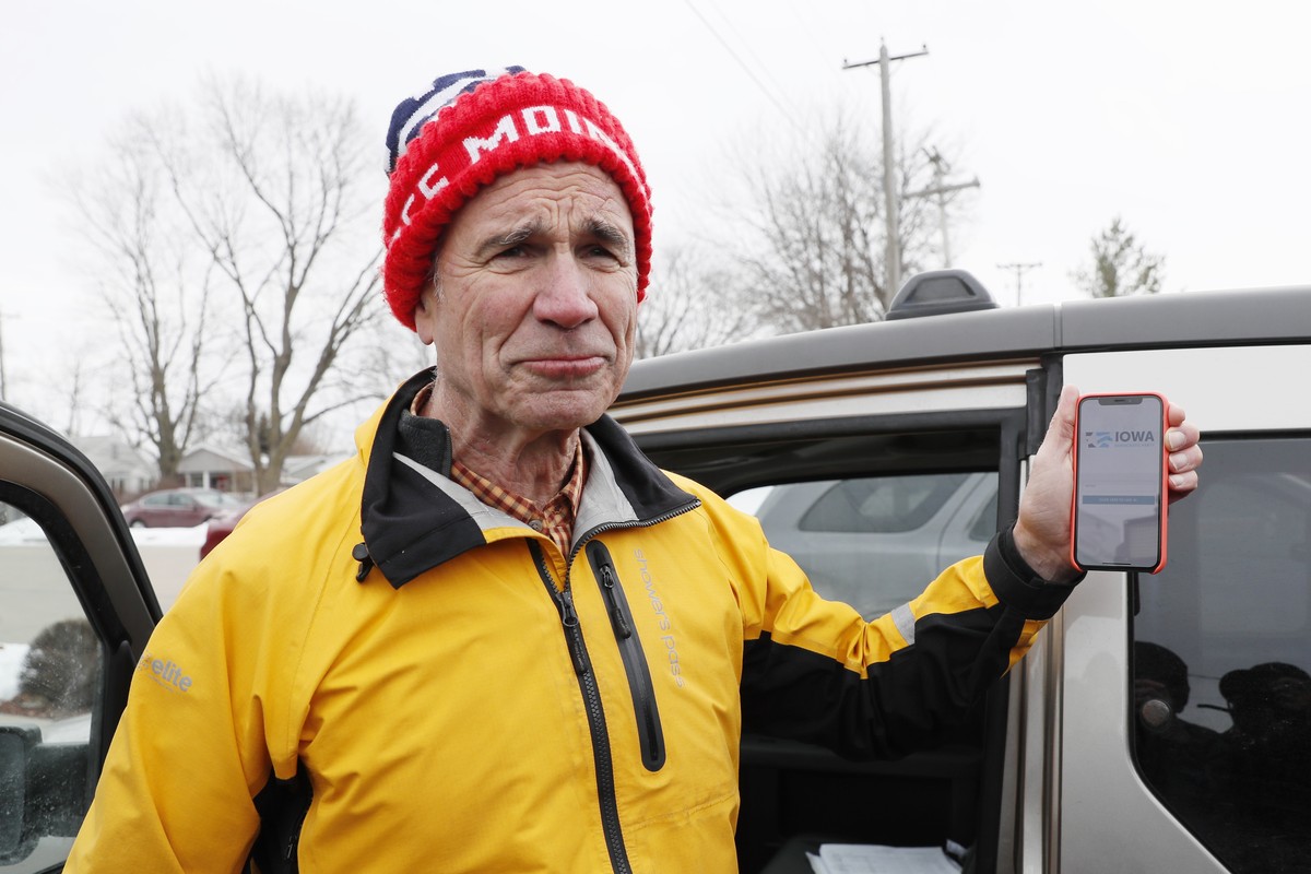 Precinct captain Carl Voss, of Des Moines, Iowa, holds his iPhone that shows the Iowa Democratic Party's caucus reporting app Tuesday, Feb. 4, 2020, in Des Moines, Iowa. (AP Photo/Charlie Neiberg ...