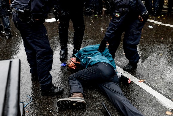 epa08827849 Riot police detain a protester during a demonstration against German coronavirus restrictions, near the Brandenburg Gate in Berlin, Germany, 18 November 2020. While German interior ministe ...