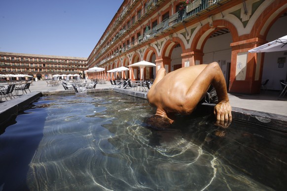 epa10104028 A man cools down in a fountain in Cordoba, southern Spain, 03 August 2022. Temperature is to reach up to 40 Celsius degrees in several parts of Spain in the fifth day of the third heat wav ...