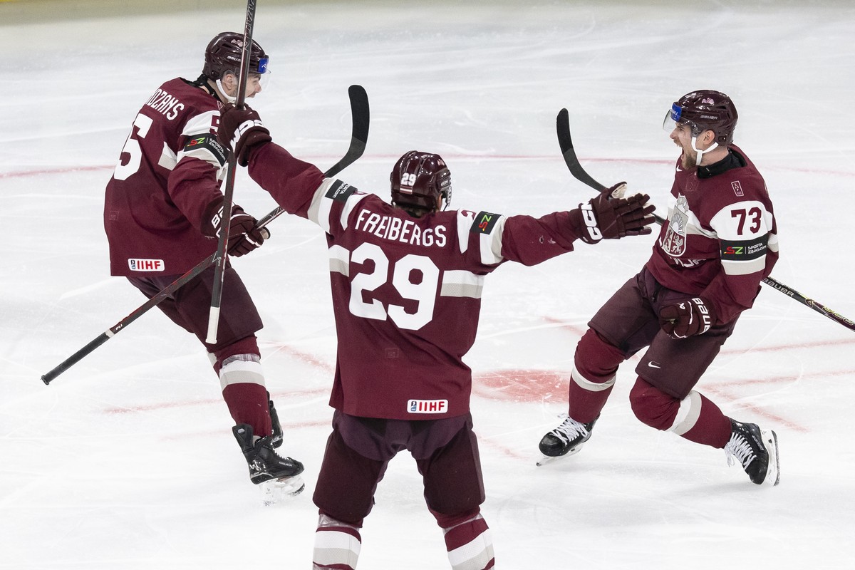 Latvia's Deniss Smirnovs, right, celebrates his 2-1 goal with Latvia's Arturs Andzans, left, and Latvia's Ralfs Freibergs, center, during the 2026 IIHF Men's Ice Hockey World Champ ...