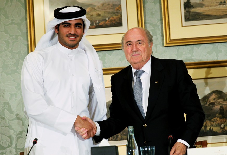 FILE - In this Saturday, Nov. 9, 2013, file photo, FIFA President Sepp Blatter, right, shakes hands with Sheik Mohammed bin Hamad al-Thani, chairman of Qatar 2022 bid committee, at a press conference  ...