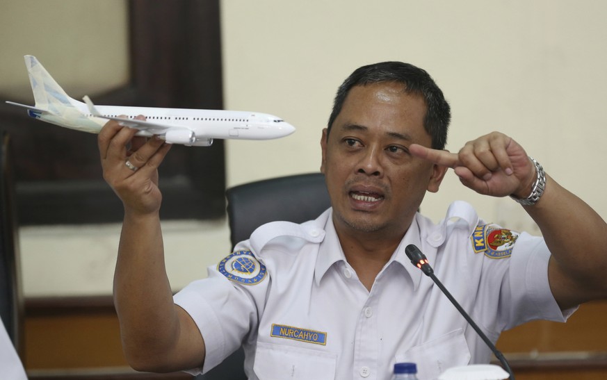 National Transportation Safety Committee investigator Nurcahyo Utomo holds a model of an airplane during a press conference on the committee&#039;s preliminary findings on their investigation on the c ...