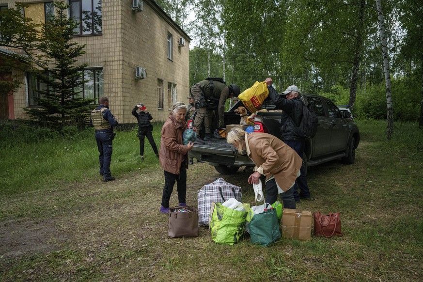 A police officer unloads belonging of people evacuated from Vovchansk, Ukraine, on Saturday, May 11, 2024. (AP Photo/Evgeniy Maloletka)
