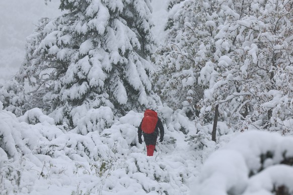 epa12419928 People walk along Morskie Oko (Eye of the Sea) during a snowfall in the Tatra Mountains, near Zakopane, southern Poland, 01 October 2025. Temperatures in Zakopane were reported at 3 degree ...