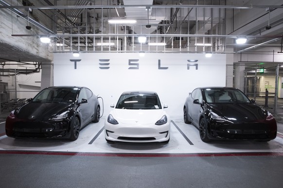 epa08997298 A Tesla Model 3 vehicle, at center, flanked by two Model Y vehicles that are used by a Tesla dealership as test-drive vehicles, are seen parked in a garage in Washington, DC, USA, 08 Febru ...