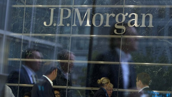 Employees are reflected in the windows of JP Morgan's Canary Wharf offices in London, in this file photo taken Sept. 19, 2013. JPMorgan Chase & Co, the largest U.S. bank by assets, reported…